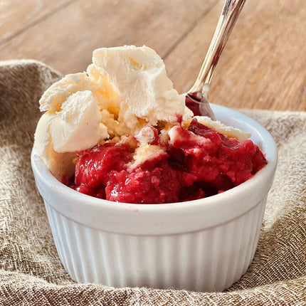 Individual portion of strawberry crumble topped with vanillla ice cream