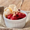 Individual portion of strawberry crumble topped with vanillla ice cream